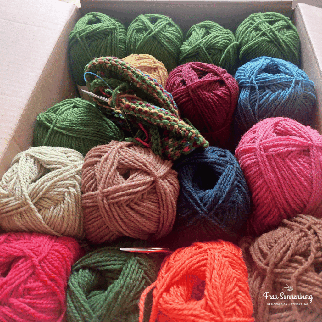 Karton mit bunter Wolle für den Sea Glass Cardigan - Anleitung von Woolandpine